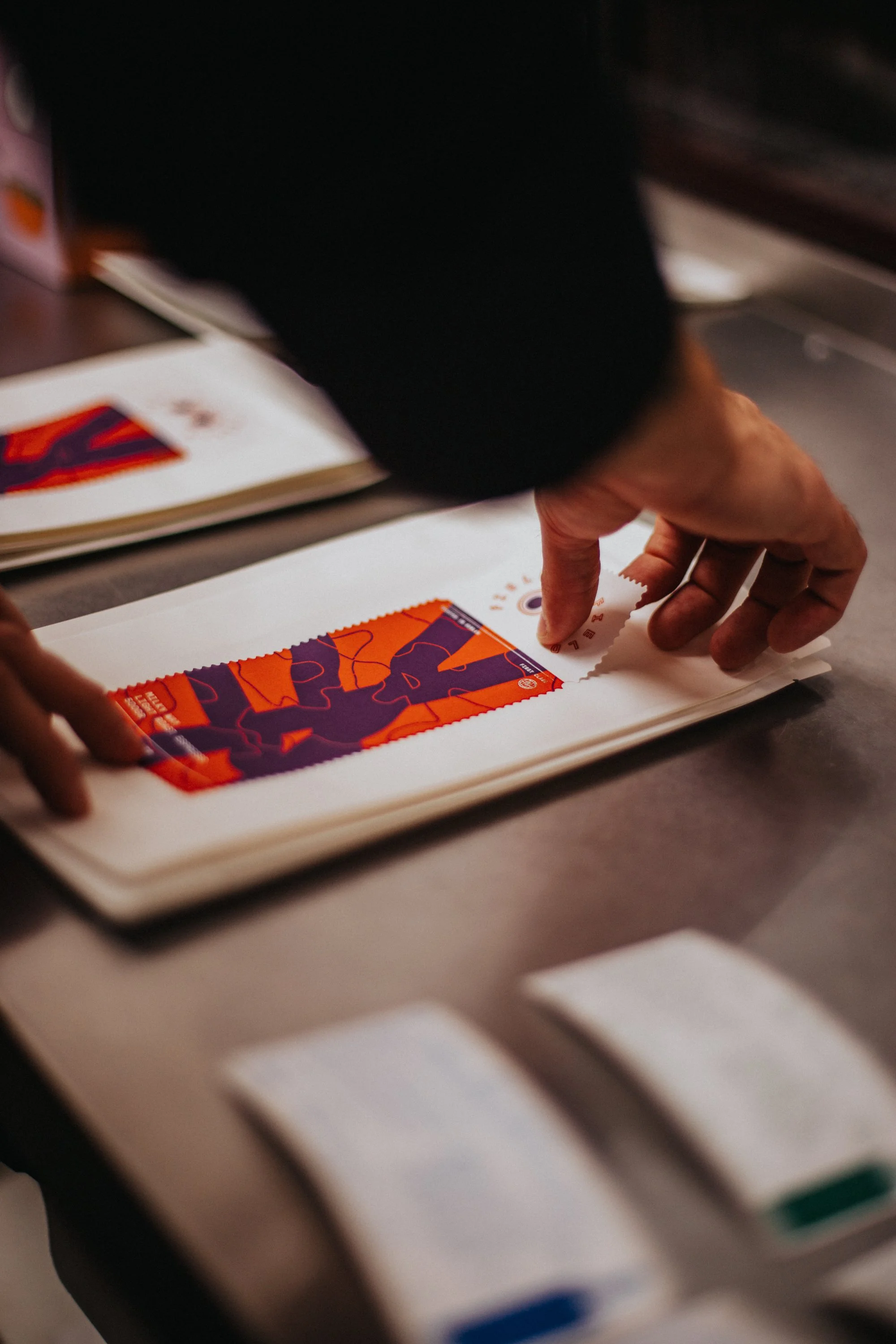 Worker applying a custom red and purple label onto a white private label coffee bag.